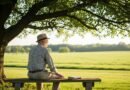 Homem descansando sob uma árvore representando a superação do esgotamento emocional na vida cristã.