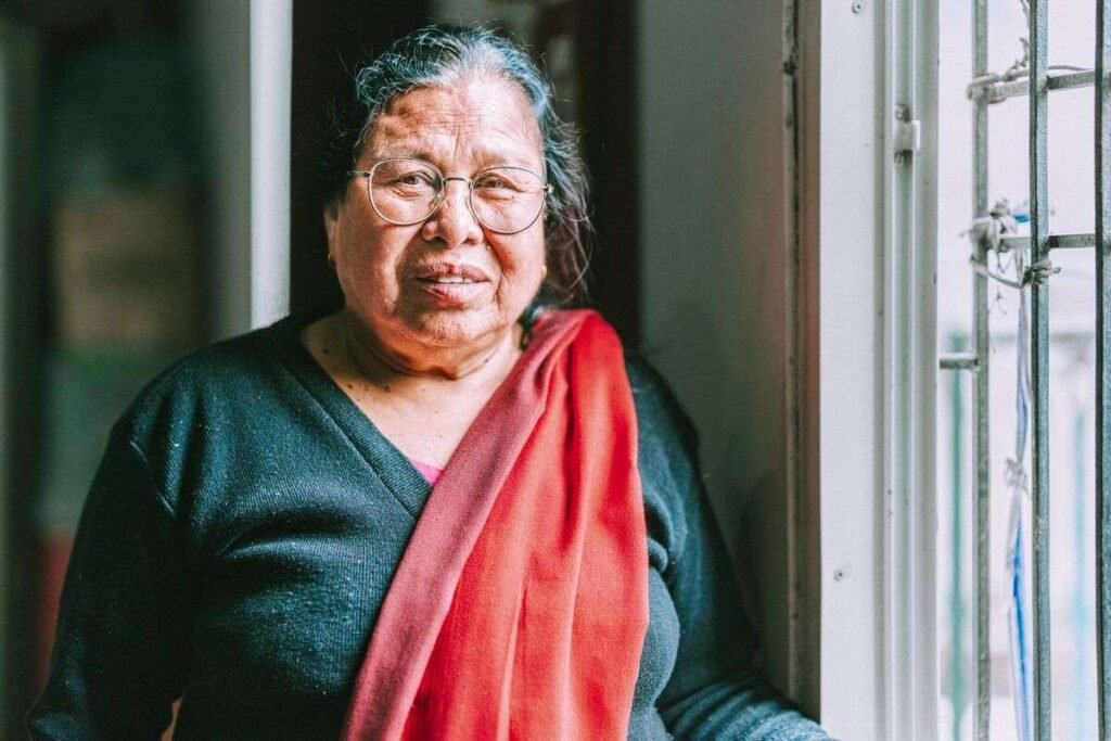 Pulmaya, uma mulher idosa nepalesa e ex-curandeira, sorrindo ao segurar sua Bíblia em áudio após sua conversão na Missão no Nepal.