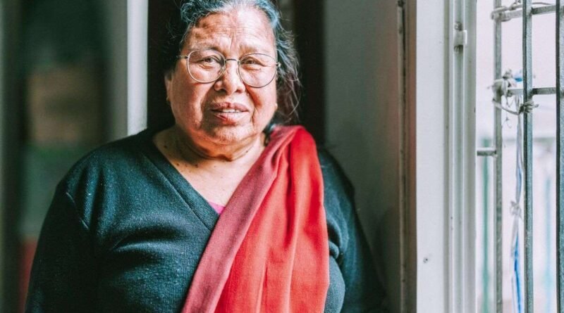 Pulmaya, uma mulher idosa nepalesa e ex-curandeira, sorrindo ao segurar sua Bíblia em áudio após sua conversão na Missão no Nepal.