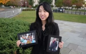 Grace Jin Drexel segura fotos do seu pai, o pastor Ezra Jin, durante denúncia sobre a perseguição aos cristãos na China