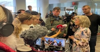 Deputada Päivi Räsänen segurando uma Bíblia em frente ao tribunal