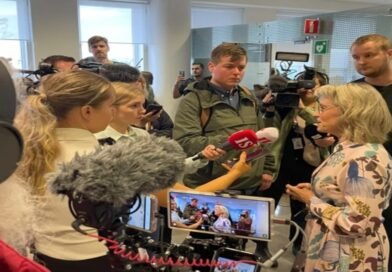 Deputada Päivi Räsänen segurando uma Bíblia em frente ao tribunal