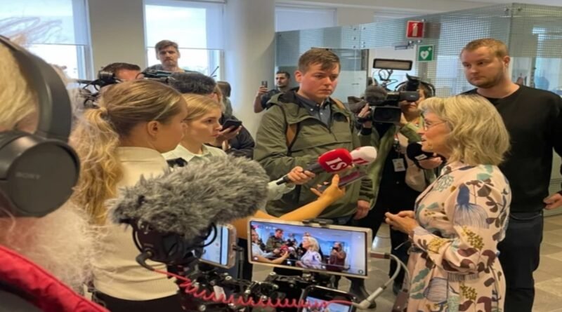 Deputada Päivi Räsänen segurando uma Bíblia em frente ao tribunal