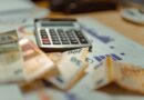 A calculator sitting on top of a pile of money